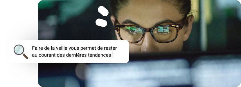 Une femme avec des lunettes fixant un ordinateur