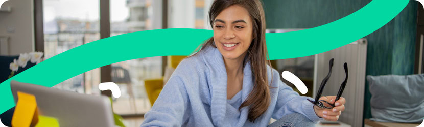 Une femme souriante qui regarde un ordinateur